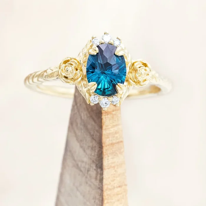 “AURORA” – OVAL ASTER CUT LAB-GROWN ALEXANDRITE ENGAGEMENT RING WITH DIAMOND & ROSE ACCENTS ON A TWISTED BAND